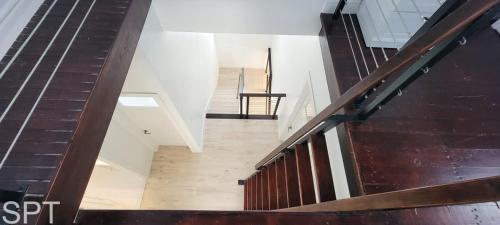 a stairway in a building with a wooden railing at Luxury Remodel - Sleeps 20 - Pool - Go VIP in South Padre Island
