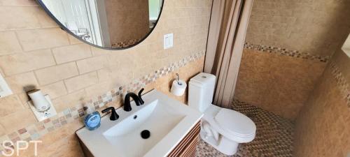 a bathroom with a sink and a toilet and a mirror at Luxury Remodel - Sleeps 20 - Pool - Go VIP in South Padre Island