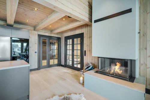 ein Wohnzimmer mit Kamin in einem Haus in der Unterkunft Modern Log Cabin For Whole Family At Geilo in Geilo