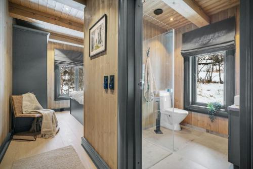ein Badezimmer mit Toilette und Fenster in der Unterkunft Modern Log Cabin For Whole Family At Geilo in Geilo