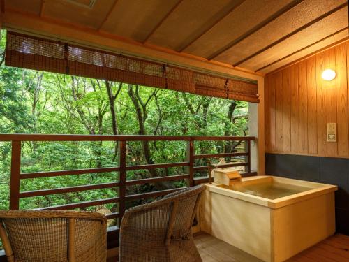 a screened in porch with a bath tub and a window at Mizunoto Reopening on April 1, 2025 in Hakone