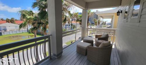 a balcony with a couch and chairs on a porch at Luxury Remodel - Sleeps 20 - Pool - Go VIP in South Padre Island