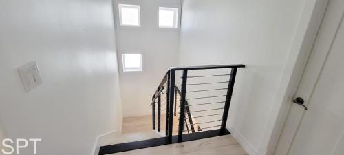 a staircase in a white room with a black railing at Luxury Remodel - Sleeps 20 - Pool - Go VIP in South Padre Island