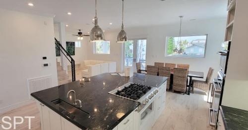 a kitchen and living room with a stove top oven at Luxury Remodel - Sleeps 20 - Pool - Go VIP in South Padre Island