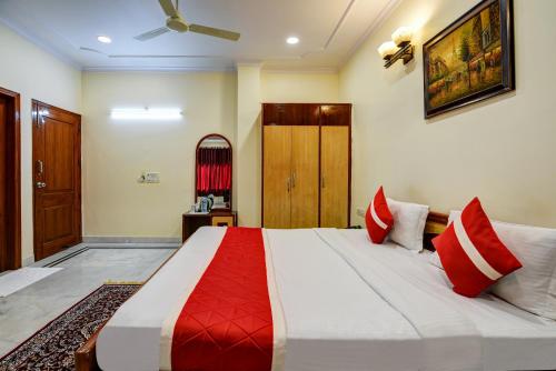 a bedroom with a large bed with red pillows at Hotel Gracious - Civil Line in Gurgaon