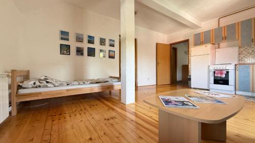 a living room with a table and a kitchen at Monte Apartment in Sarajevo