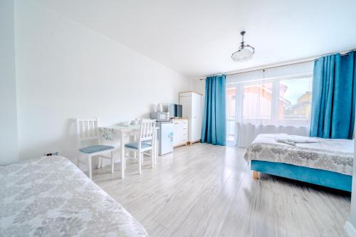 a bedroom with two beds and a desk and a table at Pablo in Niechorze
