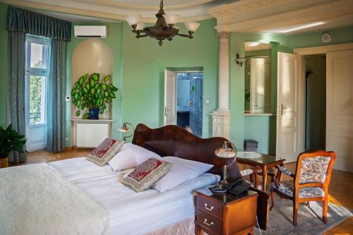 a bedroom with a bed and a table and a chair at Hotel Polonia in Kraków