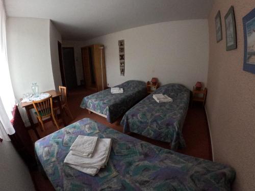 a hotel room with two beds and a table with a chair at Au Pont de la Ginéze in Barjac