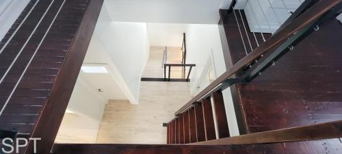 a stairway in a building with a wooden railing at Luxury Remodel - Sleeps 20 - Pool - Go VIP in South Padre Island