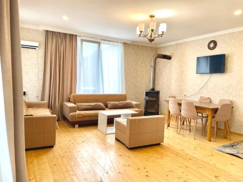 a living room with a couch and a table at Hillside Mestia ჰილსაიდ მესტია in Mestia