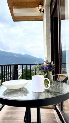 a table with a bowl on top of a balcony at Hillside Mestia ჰილსაიდ მესტია in Mestia