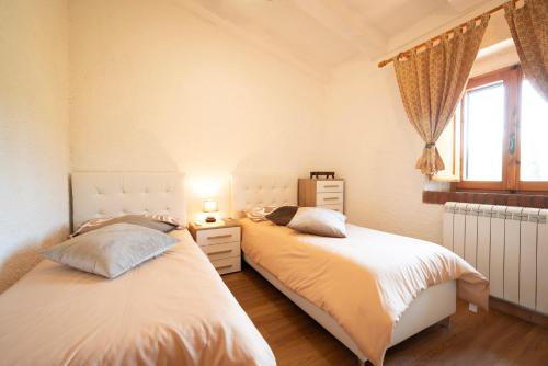 two beds in a bedroom with a window at La Casa dei Quadri in Ravi