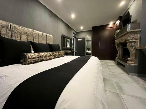 1 cama grande en blanco y negro en una habitación en OR Tambo Guest Retreat Unit 1, en Boksburg