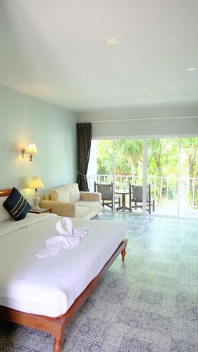 a bedroom with a large bed and a living room at Bora Bora Villa Phuket in Chalong