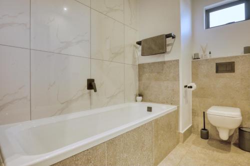 约翰内斯堡Modern Luxury 1BR in Hyde Park的浴室里有浴缸和马桶