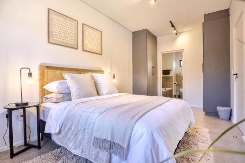 约翰内斯堡Modern Luxury 1BR in Hyde Park的一间卧室，里面有一张铺着白色床单的大床。