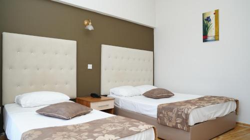 two beds in a hotel room with two bedsvisor at Hotel Sempati in Kérynia