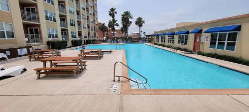 a swimming pool with tables and benches in a hotel at Gulfview II #604 in South Padre Island