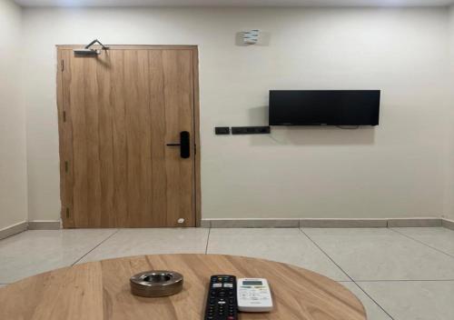 a room with a table with remote controls and a television at Aditi Hotel and Banquets in Karīmnagar