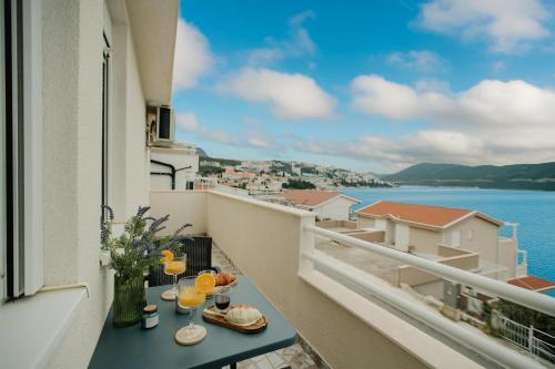 a balcony with drinks and a view of the water at Villa Green Mak in Neum