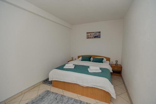 a bedroom with a bed with two towels on it at Villa Green Mak in Neum