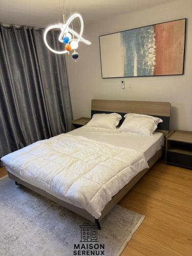 une chambre avec un lit et un lustre dans l'établissement Maison Serenux, à Douala