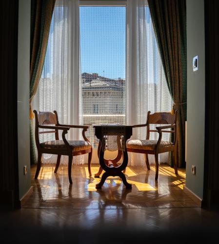 a table and two chairs in a room with a window at Hotel Polonia in Kraków