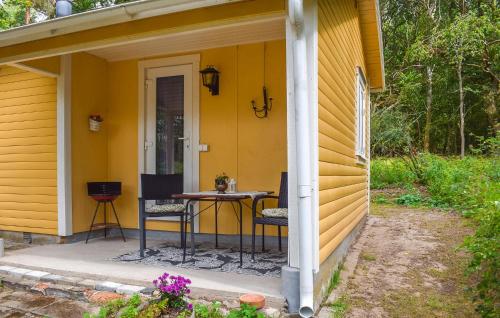 a patio with a table and chairs on a yellow house at 1 Bedroom Cozy Home In Blentarp in Blentarp