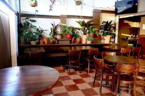a restaurant with tables and chairs and potted plants at Islington Barracks Hotel in Hamilton