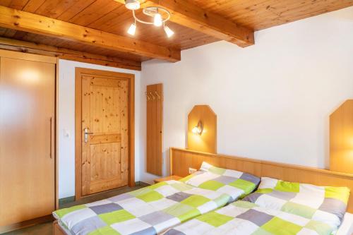 a bedroom with a bed and a wooden ceiling at Gasthaus Mamoosen in Penning