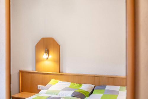 a bedroom with a bed and a light on the wall at Gasthaus Mamoosen in Penning