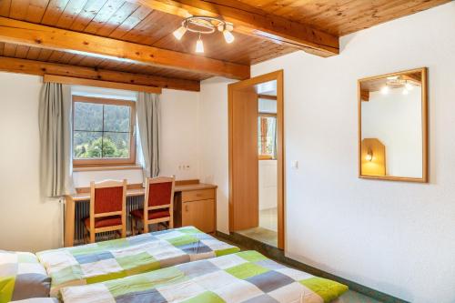 a bedroom with a bed and a table and chairs at Gasthaus Mamoosen in Penning