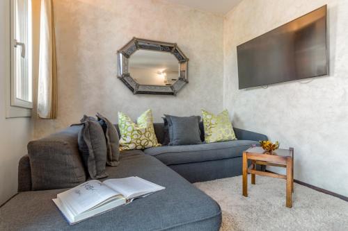 a living room with a blue couch and a mirror at MURANO Suites BOUTIQUE Apartments adults only in Murano