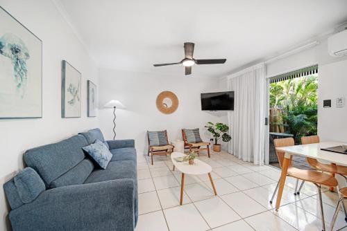 a living room with a blue couch and a table at Beachcomber Peregian Beach in Peregian Beach