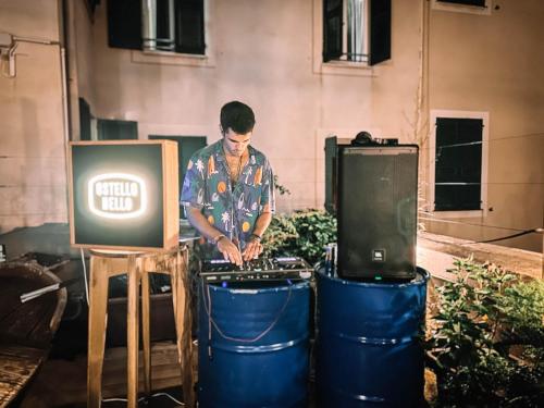 a man standing next to a television and drums at Ostello Bello Genova in Genova