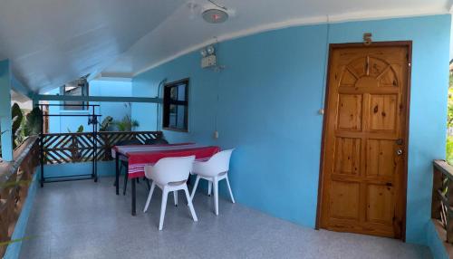 a room with a table and chairs and a blue wall at A&C Aquino Guesthouse in Moalboal