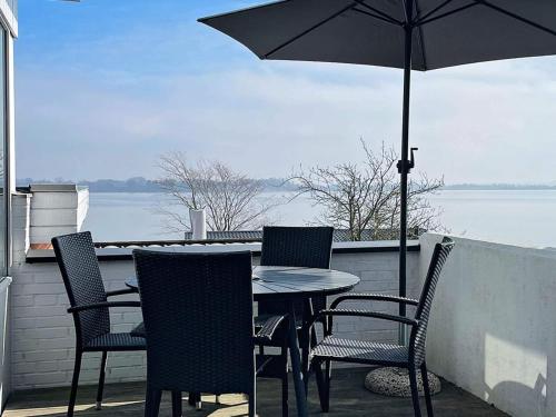 a table and chairs on a balcony with an umbrella at 4 person holiday home in Gråsten-By Traum in Gråsten