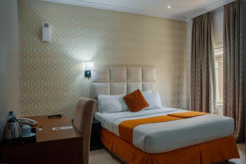 a hotel room with a bed and a desk and a bed sidx sidx sidx sidx at Morning Side Suites in Lagos