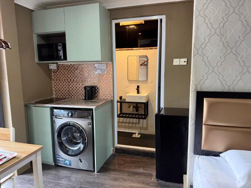 a small kitchen with a washing machine in a room at HOTEL JJH Aliwal in Singapore