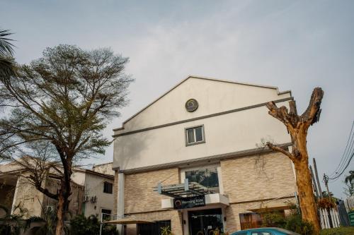 a white building with a tree in front of it at Morning Side Suites in Lagos