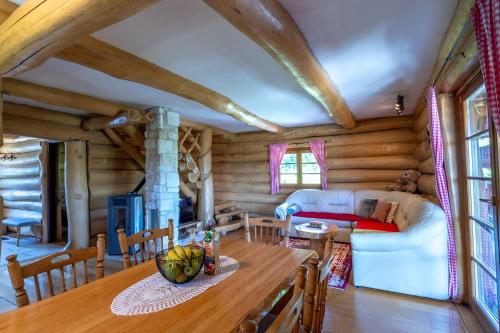 a dining room and living room in a log cabin at BeaR's LOG in Seliste Dreznicko