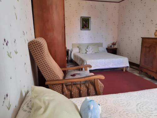 a room with two beds and a chair and a bed at Gîte 132, Cœur Châteaux in Noyers-sur-Cher