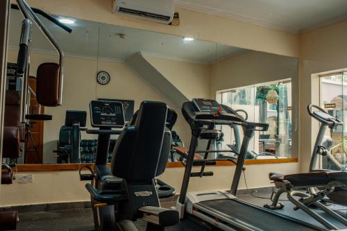 a gym with several tread machines and a mirror at Morning Side Suites in Lagos
