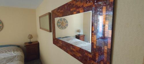 a mirror on a wall in a bedroom at Chambre Swingy - Gîte les Zazous in Lormes