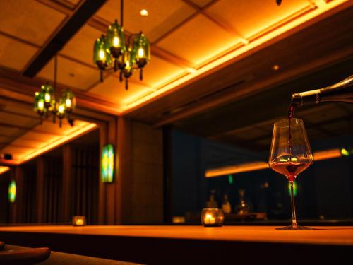 a wine glass sitting on a table in a bar at UMITO Atami Bettei in Atami