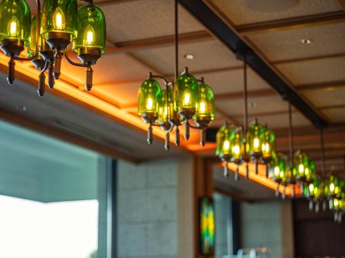 a row of green lights hanging from a ceiling at UMITO Atami Bettei in Atami