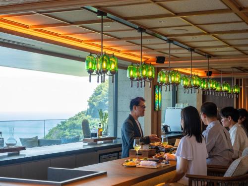 a group of people sitting at a table in a restaurant at UMITO Atami Bettei in Atami