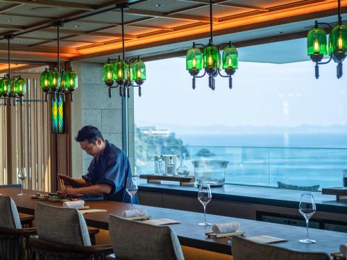 a man sitting at a table in a restaurant at UMITO Atami Bettei in Atami