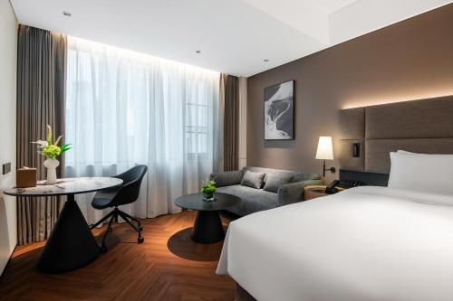 a hotel room with a bed and a couch at 深圳南山万科云城城际酒店 in Shenzhen